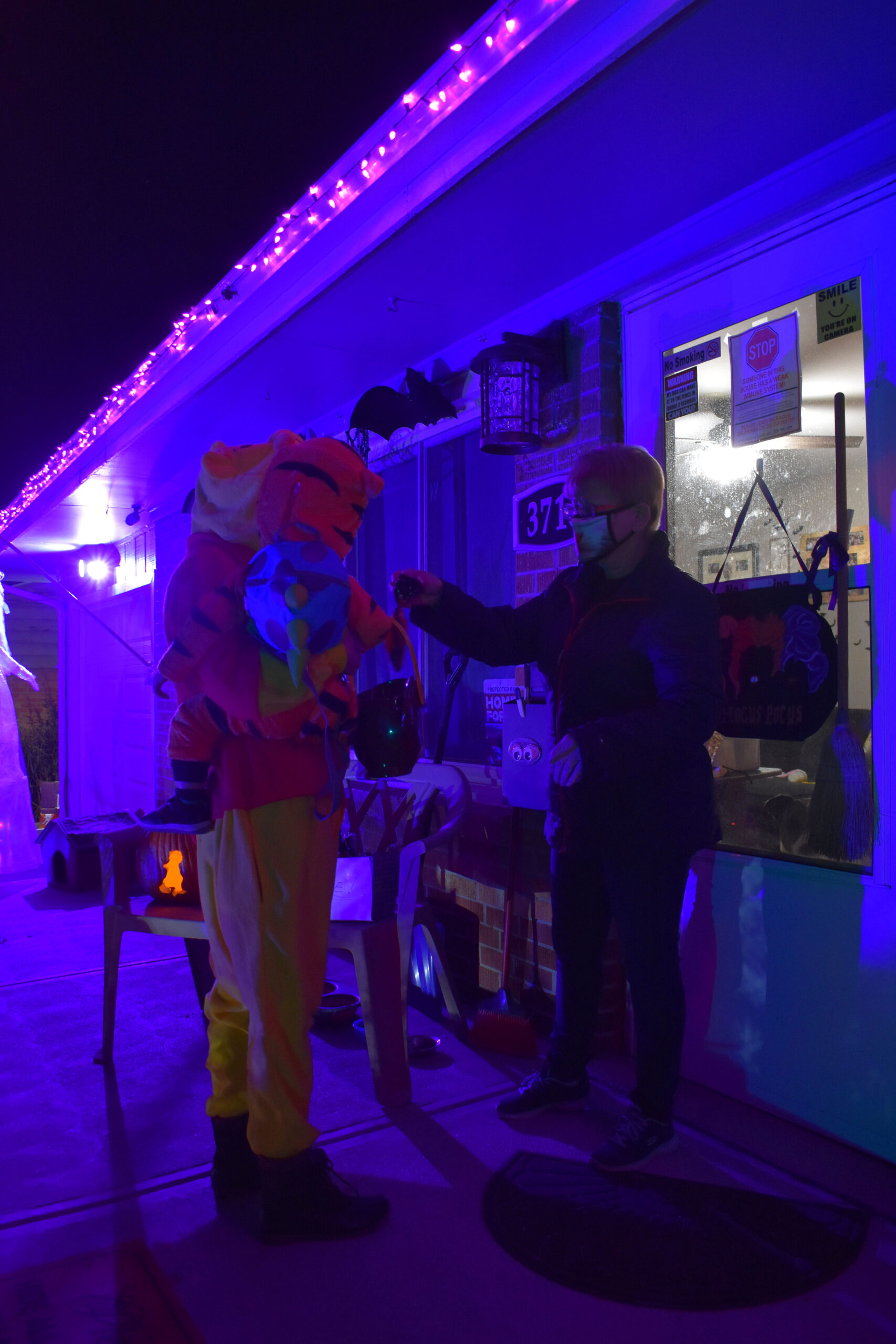 McCawley hands out candy to a woman and her son on Halloween. Westminster, Colo., Oct. 31, 2020. (Kerry McCawley/MSU Denver)