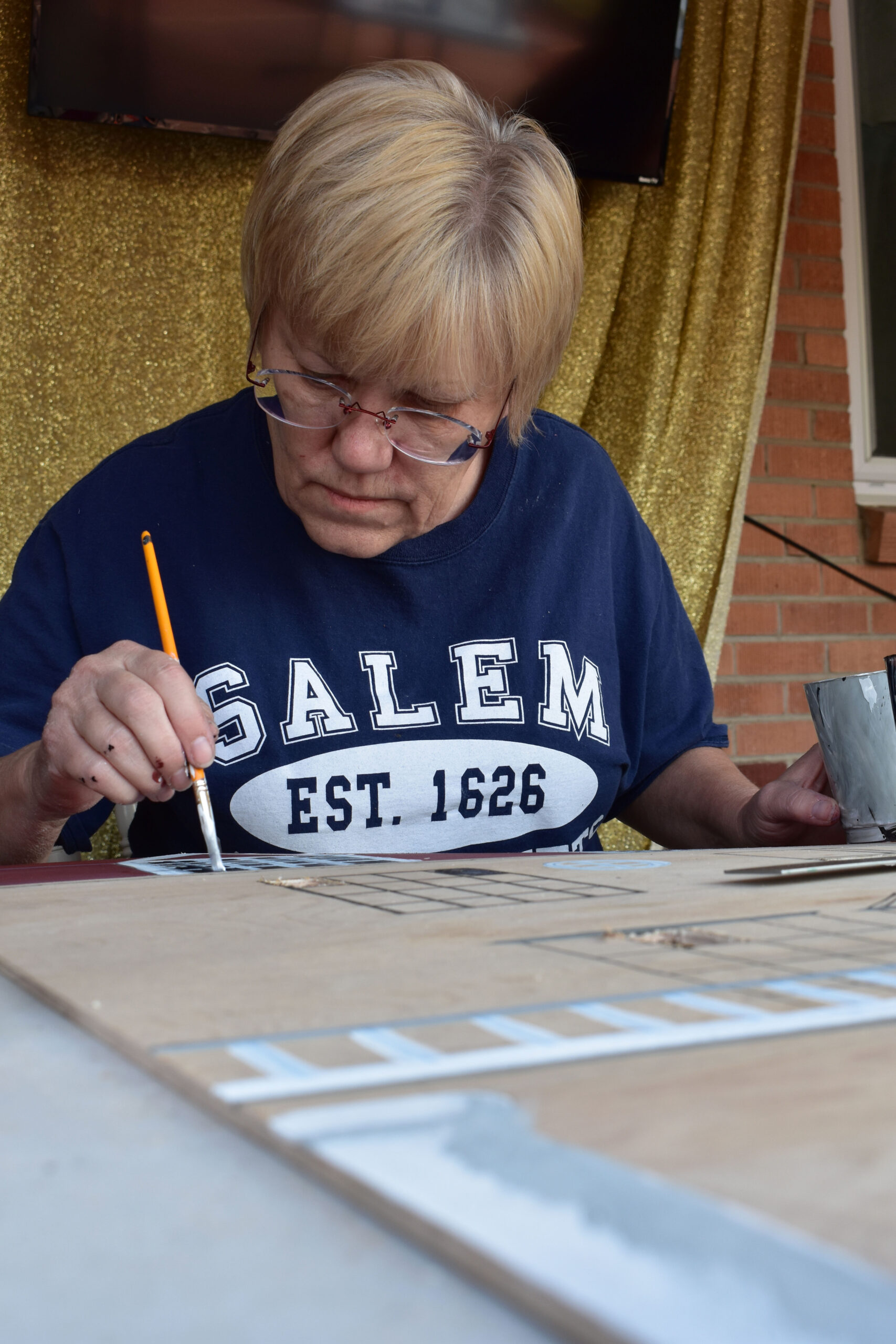 A moment of solitude in McCawley's make-shift studio on her porch. She paints the windows on her replica of the Stanley Hotel, in a homage to Stephen King's novel "The Shining." Westminster, Colo. Oct. 8, 2020. (Kerry McCawley/MSU Denver)