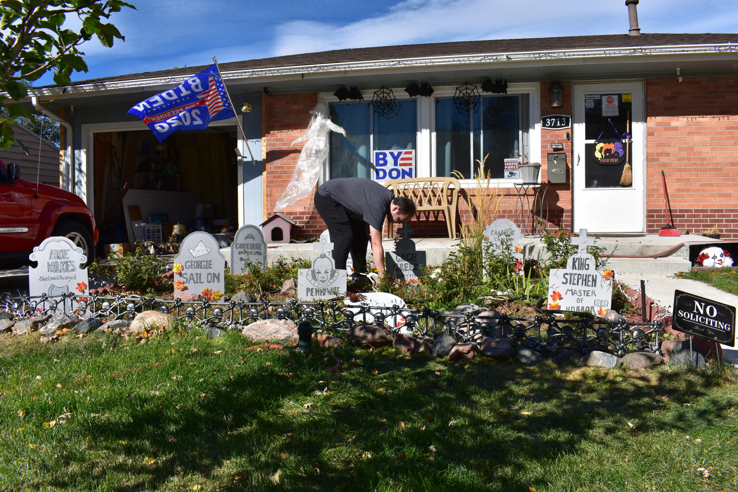 McCawley's son-in-law, Joseph Caudill, positions skeleton cats around Gage Creed's headstone based on Stephen King's novel, "Pet Sematary." Westminster, Colo., Oct. 12, 2020. (Kerry McCawley/MSU Denver)